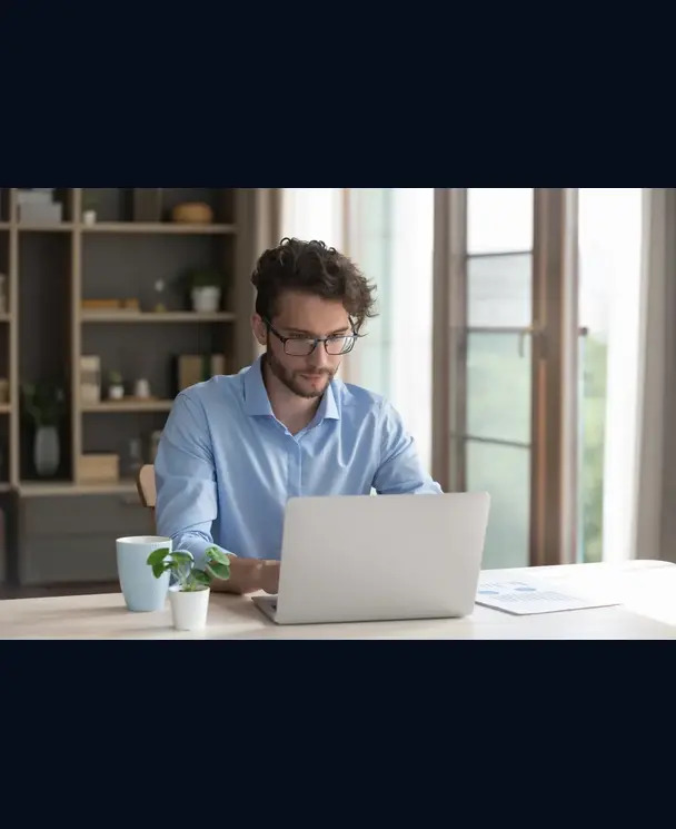 Professional Magento web developer working on a laptop in a bright Toronto office setting.
